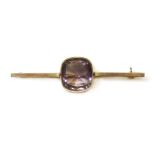 An Edwardian gold single stone amethyst bar brooch,cushion-shaped amethyst, rub set to a polished