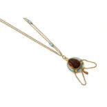 A Victorian gold garnet and blue enamel pendant, a large pear-shaped cabochon garnet, rub set to a