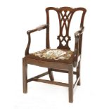 A George III mahogany elbow chair,with a pieced splat, drop-in seat, scrolled arms, and moulded