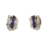 A pair of cased Art Deco style diamond and sapphire vertical scroll earrings, channel set to the