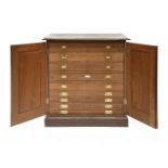 An Edwardian mahogany plan or collector's chest, the two panelled doors enclosing nine drawers, with