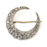 A late Victorian diamond set crescent brooch, a closed crescent with two rows of old European, old