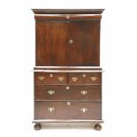 A mahogany cupboard,18th century, with a cushion drawer over two doors enclosing a fitted