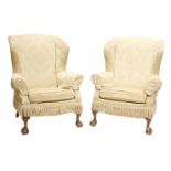 A pair of wing armchairs,mid-20th century, with loose covers, and claw and ball front feet (2)