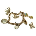 A 9ct gold curb link chain bracelet,with padlock and five assorted charms, the five charms