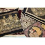 A collection of Indian wall hangings and a cushion, all embroidered in metallic threads, some with