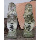 A pair of reconstituted stone lions on hind legs with shields (2)