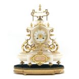 A late 19th Century alabaster and gilt metal clock, in the rococo style with an urn finial and