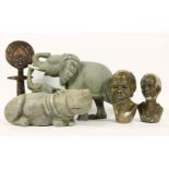 A collection of African carved items, to include a carved stone hippo, an elephant figure group, two