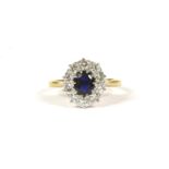 A sapphire and diamond oval cluster ring, with an oval mixed cut sapphire, claw set to the centre, a