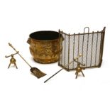 A brass log bin, embossed with fleur-de-lys and fruit and applied lion's masks, 42cm diameter, a