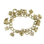 A 9ct gold curb link charm bracelet, with padlock, with sixteen assorted gold charms, to include a