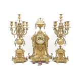 An early 20th Century gilt metal clock garniture, the clock with an urn finial over a body decorated