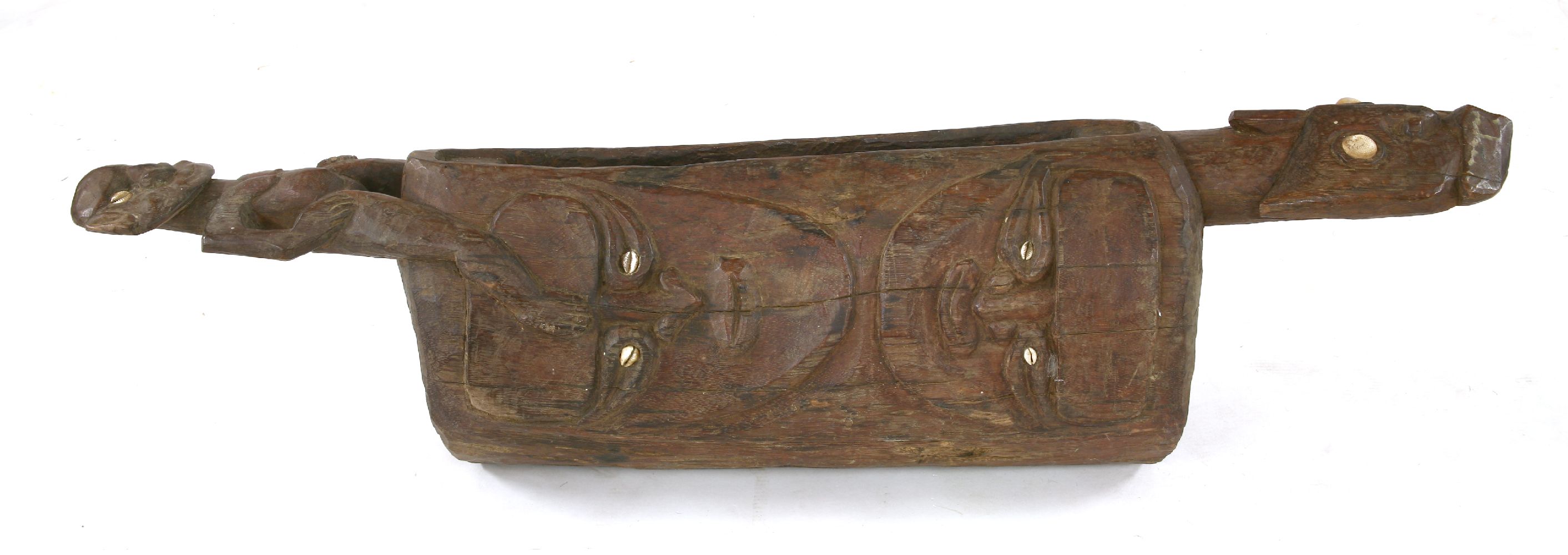 A SLIT DRUM,mid-20th century, a tribal carved wooden slit drum with shell decoration, from the Sepik