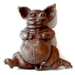 A FRENCH CARVED PIG,early-mid 20th century, a walnut seated pig with flat back, probably from a