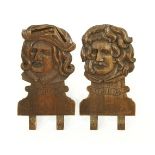 A PAIR OF CARVED OAK PEDIMENTS,one in the form of Teniers, the other, Raphael, each 58cm high (2)
