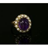 A gold amethyst cabochon and split pearl cluster ring, a central oval amethyst cabochon claw set
