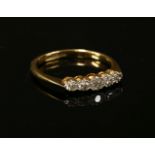 A gold five stone diamond ring, five eight cut diamonds, illusion set to knife edge shoulders and