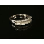 A white gold three row diamond ring with a tapering plain polished shank, marked 750, size M, 2.91g