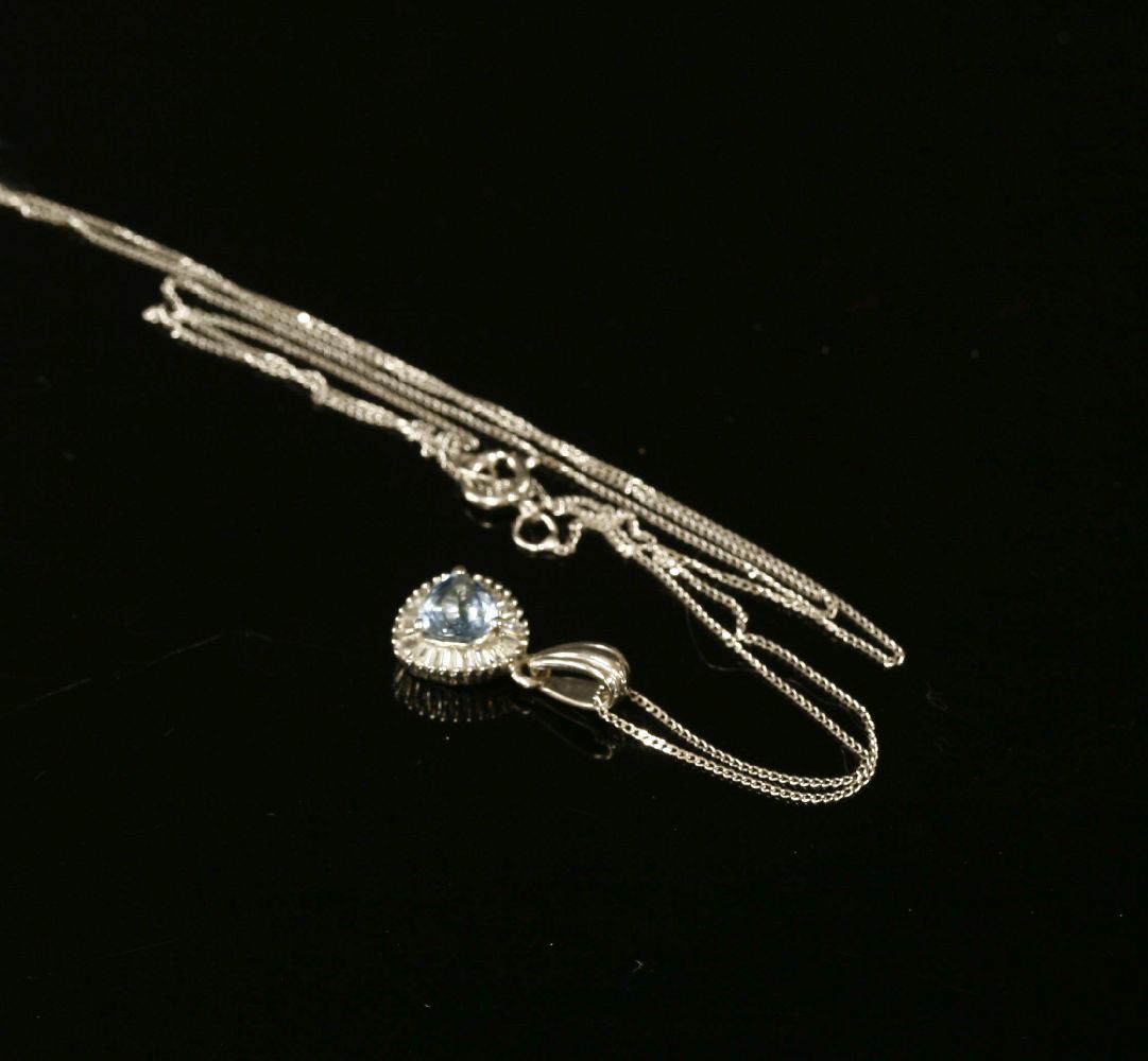A white gold aquamarine and diamond cluster pendant, a trilogy cut aquamarine claw set to a border