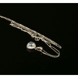 A white gold aquamarine and diamond cluster pendant, a trilogy cut aquamarine claw set to a border