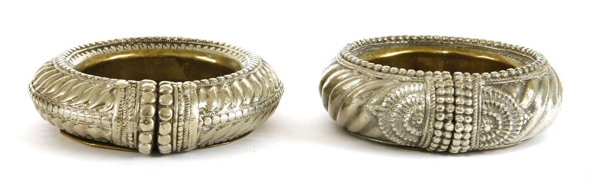 A pair of Ashanti nickel(?) currency bangles,19th century, of cable twist form, now with brass