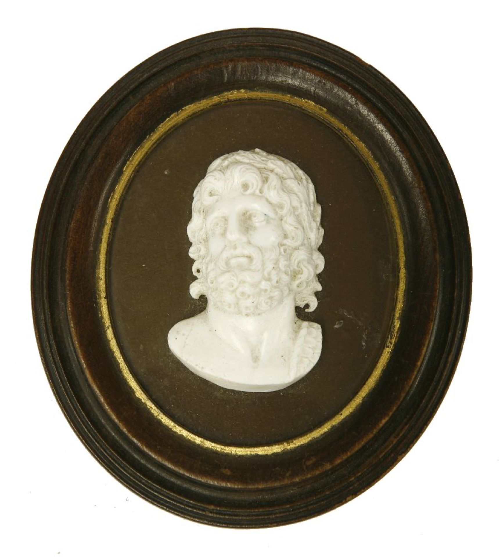 A glass paste medallion of Apollo,applied on glass,8.5cm high, within a parcel gilt oval wood frame