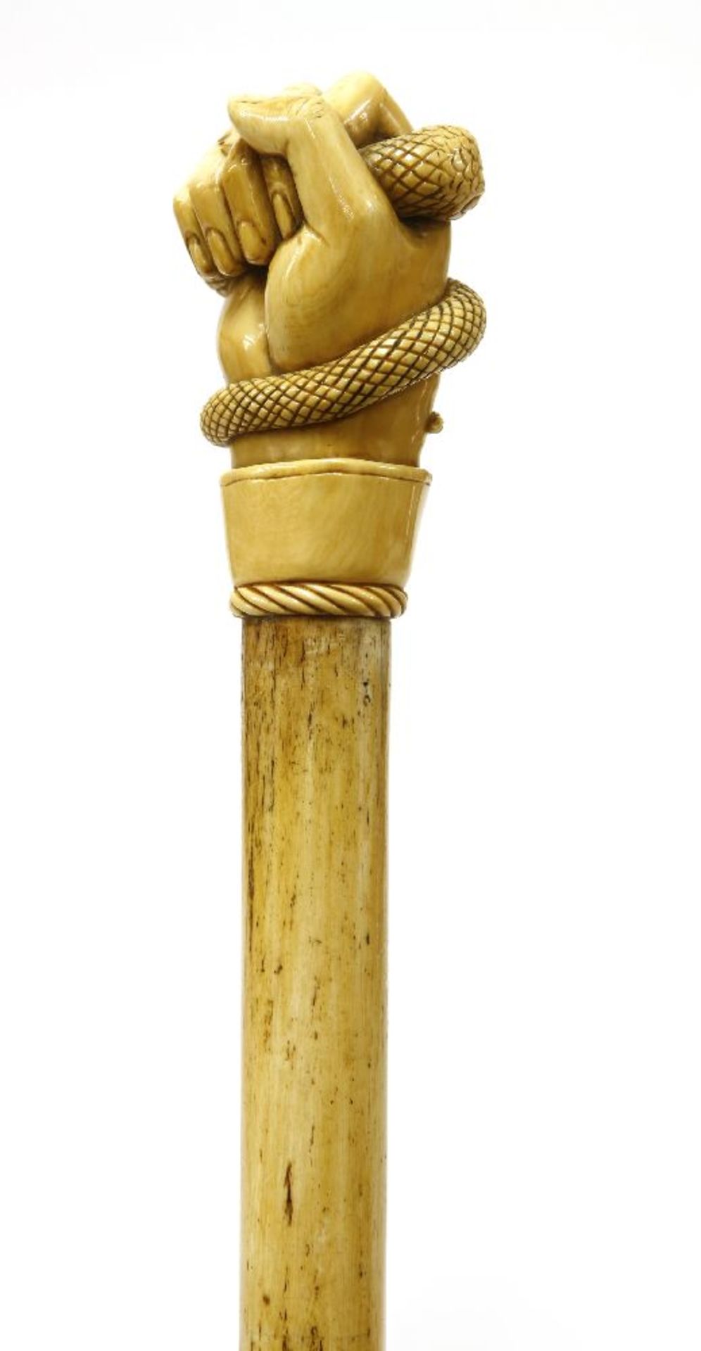 A marine ivory and whalebone walking stick,the top finely carved with a hand gripping a serpent, the