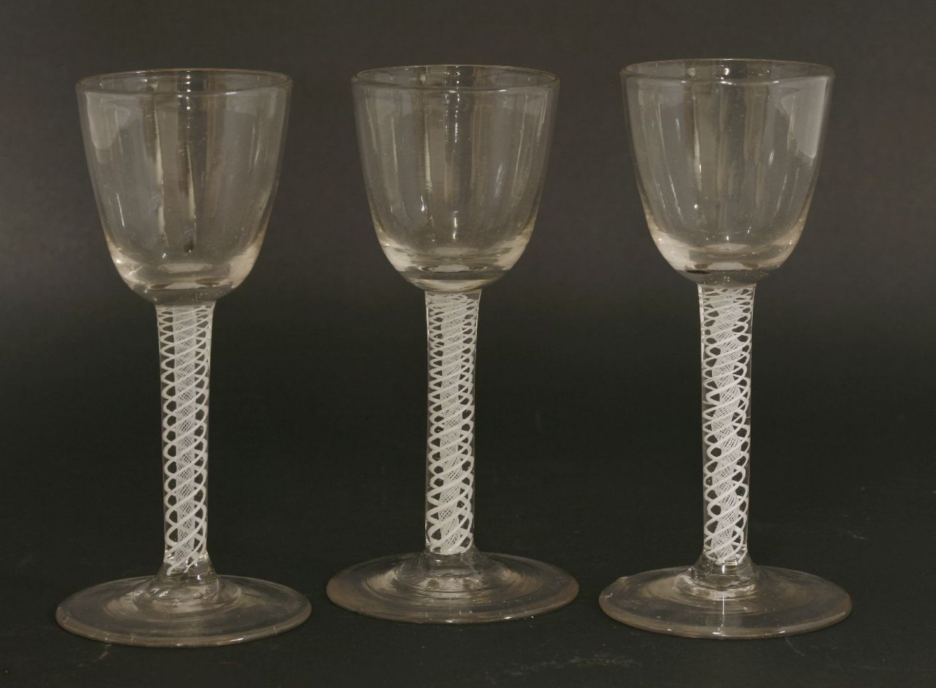 Three George III wine glasses,each with a round funnel bowl over an opaque twist stem,14.5cm high (