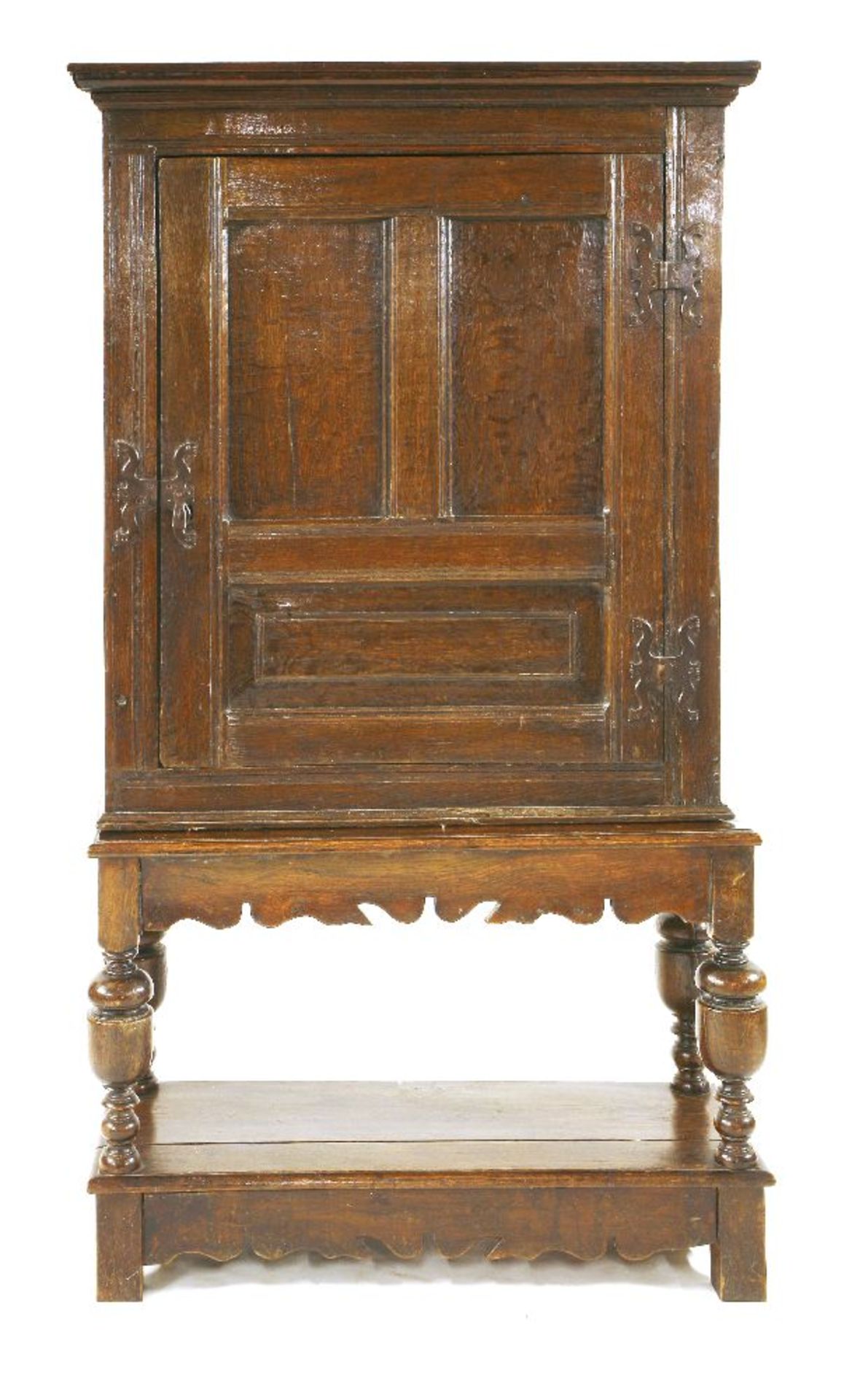 An oak cupboard on stand,18th century and later, the cupboard with a single triple panelled door and