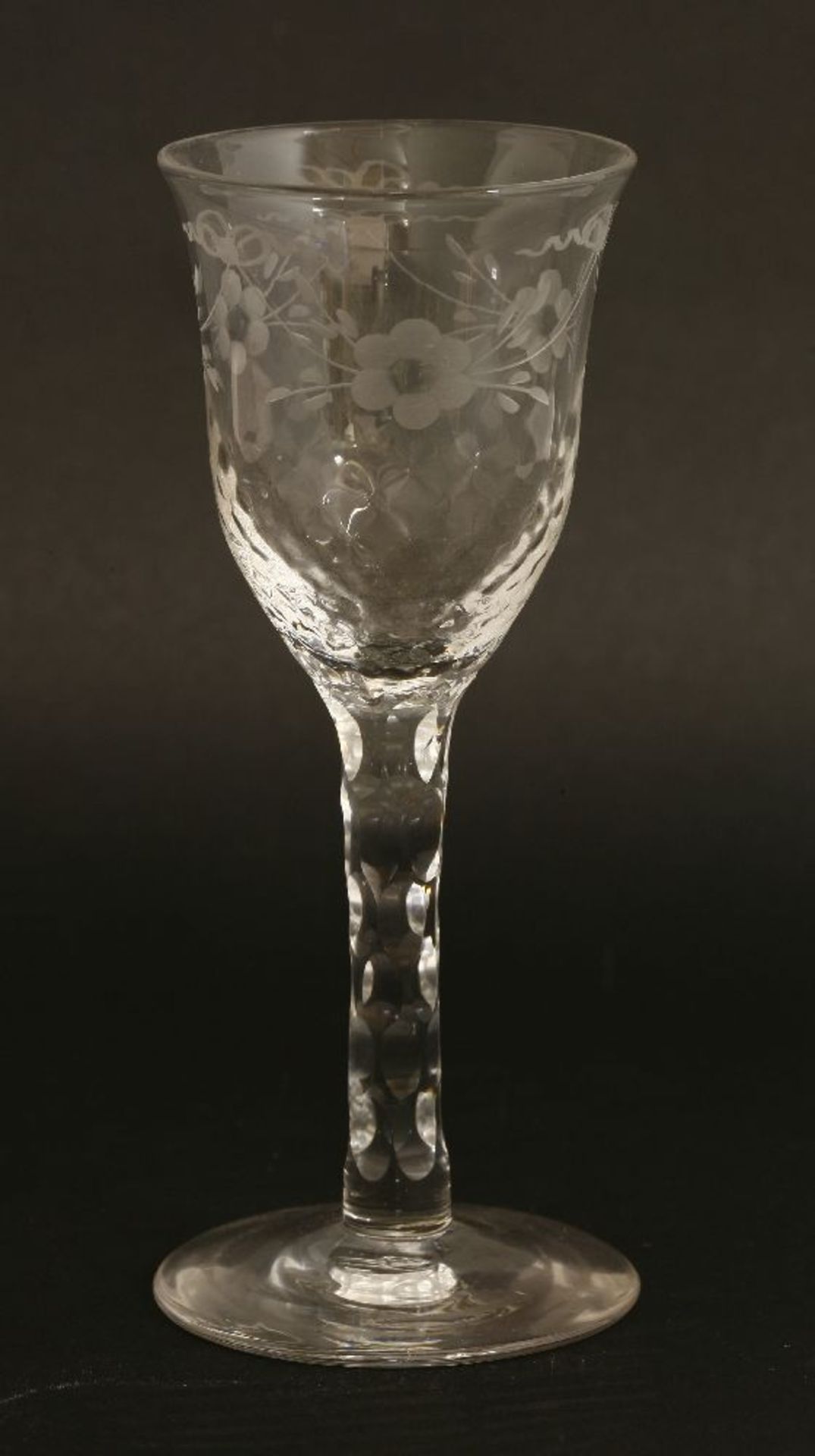 A George III wine glass,the ogee bowl engraved with ribbon tied flowers over 'dimples' on a facet