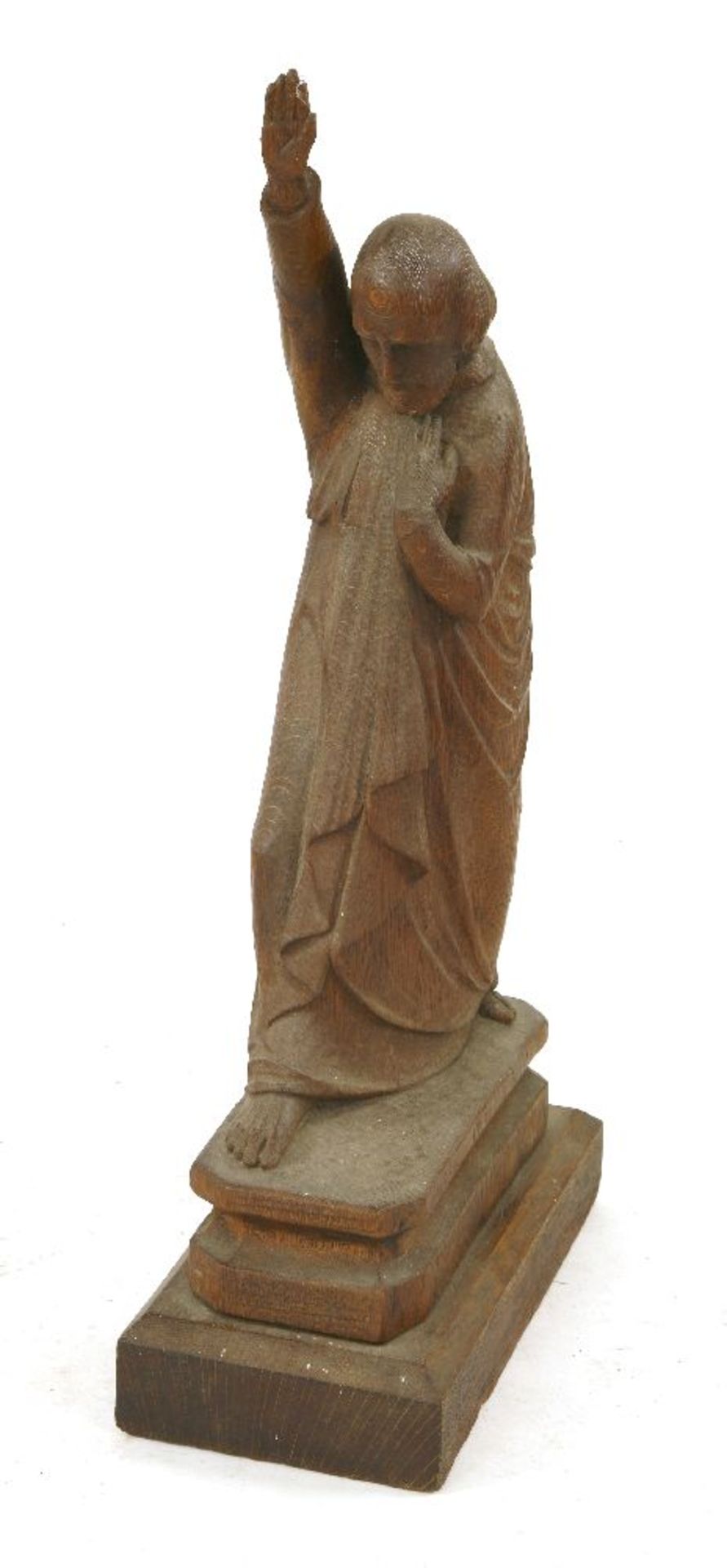 A carved oak figure,20th century, of a clergyman holding one arm aloft whilst clutching his cloak,