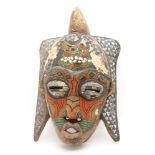 A North African carved tribal mask with beadwork detail, 53cm high