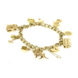 A gold charm bracelet, with padlock and nine assorted charms to include a 9ct gold bus, a St