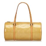 A Louis Vuitton Vernis Bedford handbag, featuring a cream vernis leather body, flat leather