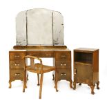 An Art Deco walnut dressing table, with a bevelled edge triptych mirror, over seven drawers with