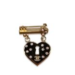 A Chanel CC Heart Lock and Key Brooch, featuring a gold- tone and black enamel diamante heart and