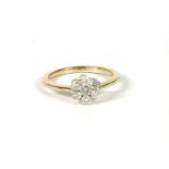 A gold diamond Daisy cluster ring, claw set to tapering shoulders and a plain polished shank, marked