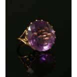 A gold single stone amethyst ring, a circular cut amethyst, claw set to split shoulders and a