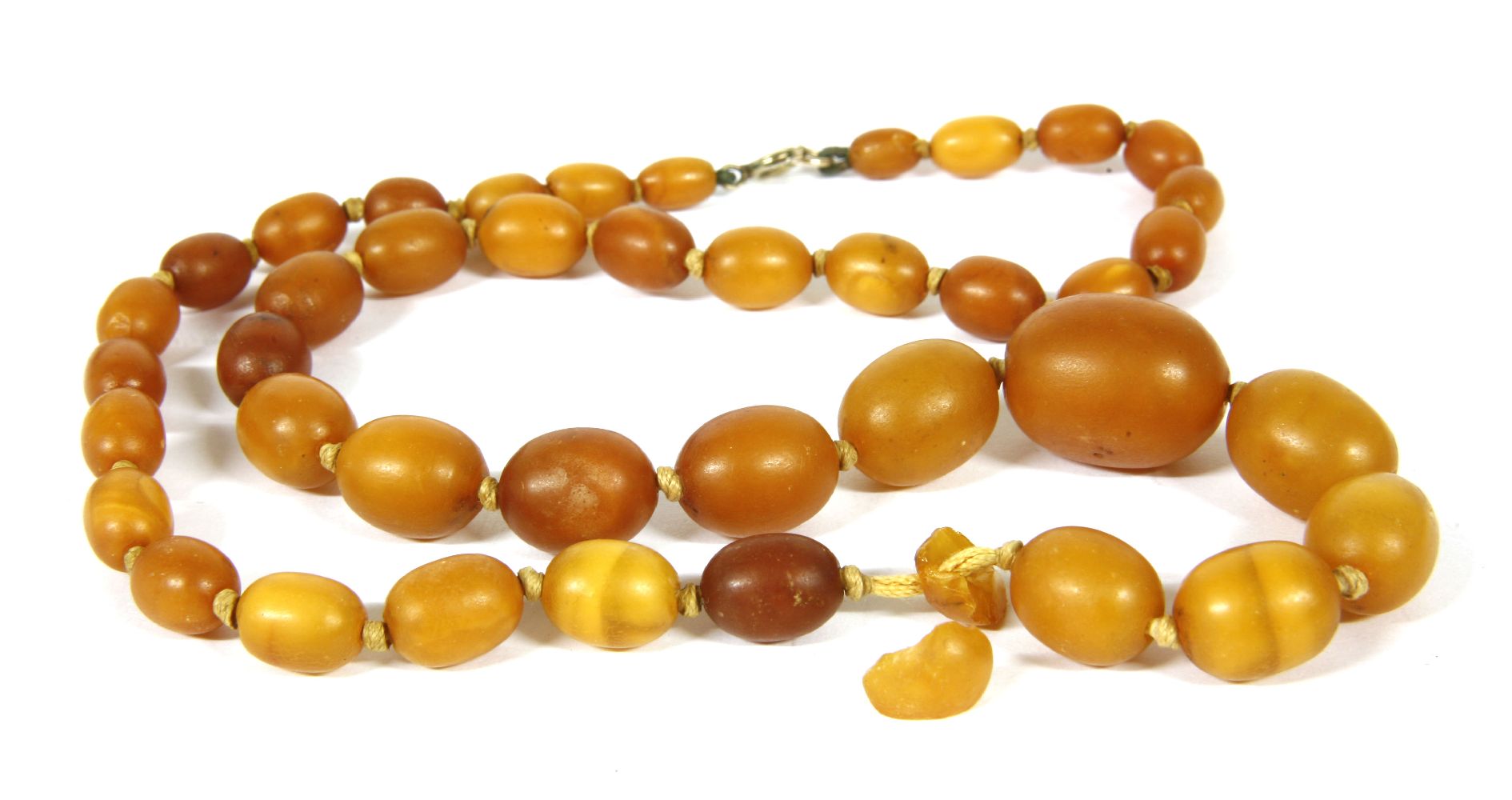 A single row graduated olive shaped amber bead necklace, 23.53g