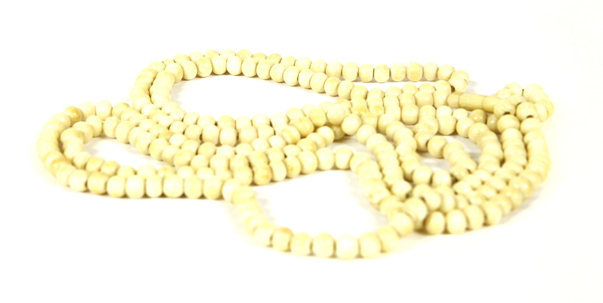 A silver row ivory bead necklace, of opera length, c.1900, 74cm drop, 52.25g