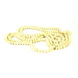 A silver row ivory bead necklace, of opera length, c.1900, 74cm drop, 52.25g