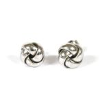 A pair of 18ct white gold knot earrings retailed by Cellini, with post and butterfly fittings, 2.