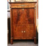 An Empire mahogany and gilt mounted escritoire, with a marble top, over a frieze drawer, with a drop