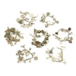 Six assorted silver charm bracelets, all with various charms attached