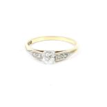 A gold single stone cushion cut diamond ring, with diamond set shoulders, marked 18ct and PLAT, size