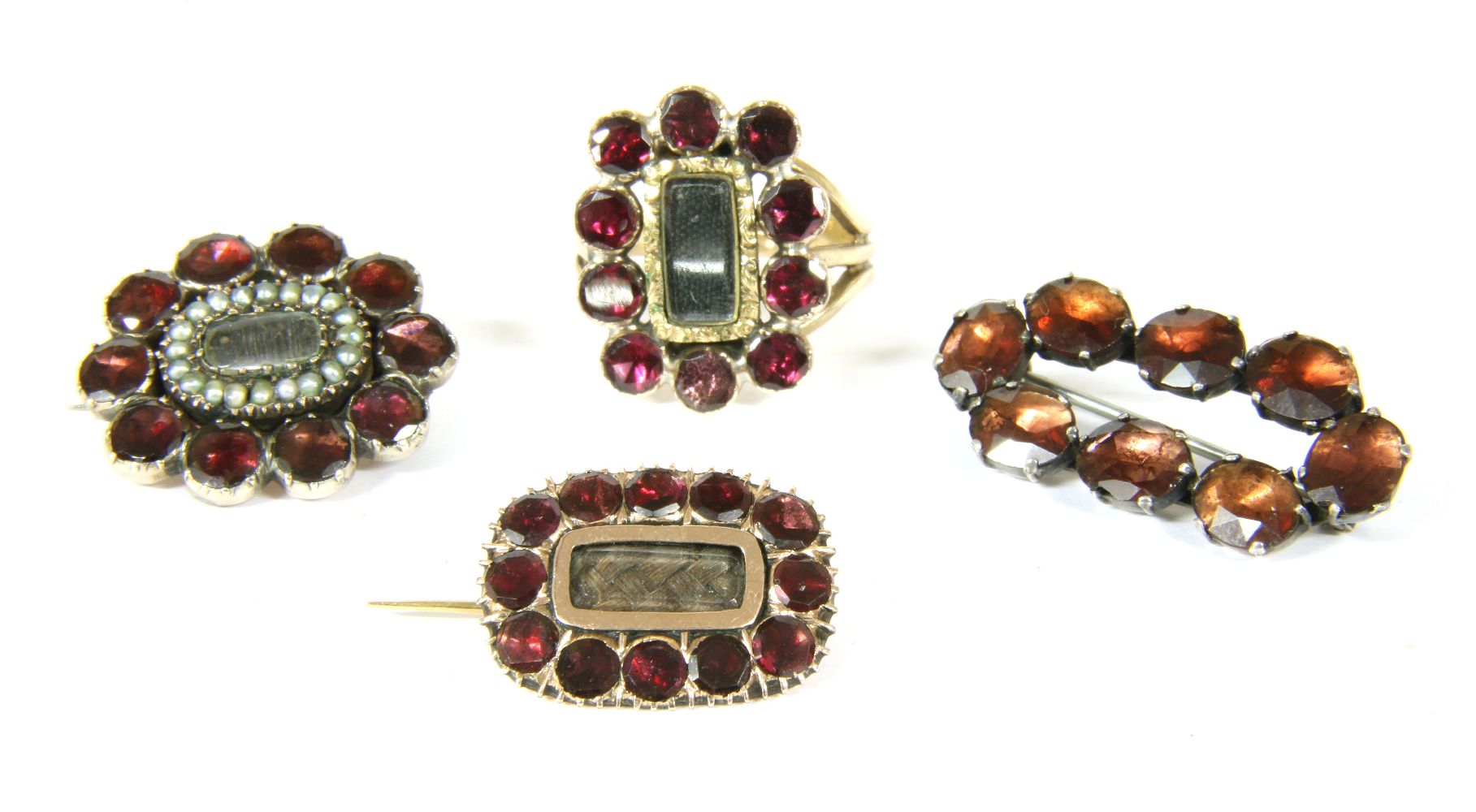 Three Georgian set memorial brooches, including two gold examples, set with flat cut garnets with