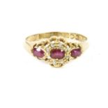 An 18ct gold three stone ruby, and diamond cluster ring (one stone deficient)