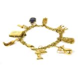 An Italian gold anchor link chain, with ten assorted gold charms including a gold hollow Tutankhamun