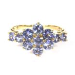 A gold tanzanite cluster ring, with tanzanite set shoulders and a plain polished shank marked 9k 1.